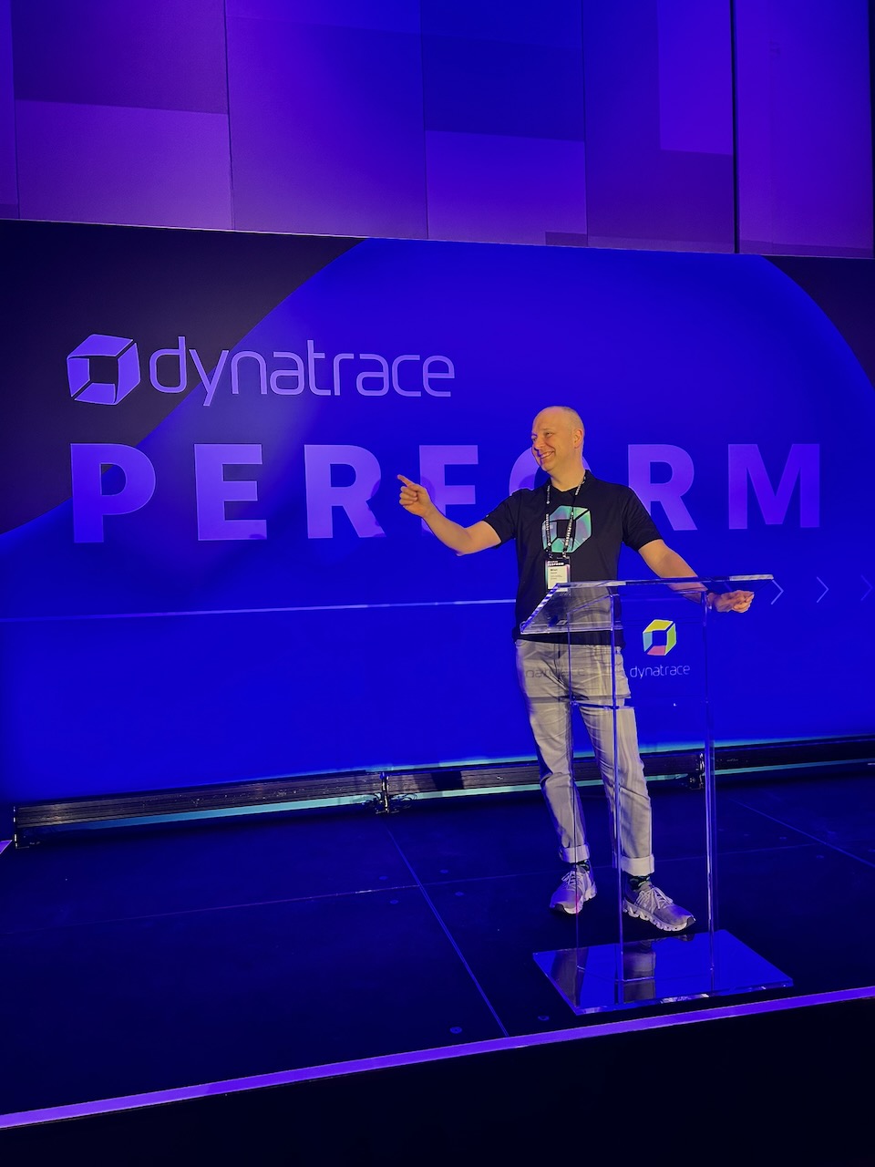 Milan on stage at Dynatrace Perform, pointing toward the audience